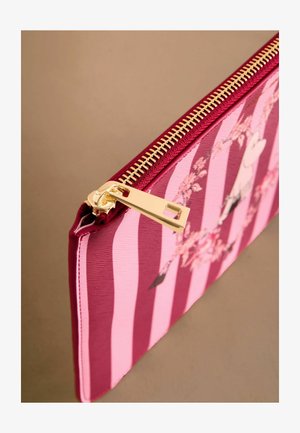 Sūklis ar rāvējslēdzēju, izgatavots no sarkanas un rozā svītraina auduma, kuram ir ziedu raksti. Zelta rāvējslēdzēja aparatūra akcentē teksturēto virsmu.