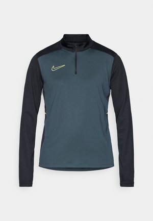Mørkeblå half-zip træningstrøje med sorte lange ærmer, der har et gult Nike-logo på brystet og teksturerede sidepaneler.