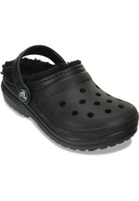 Zuecos negros con un suave forro de piel, fabricados con un material texturizado, que presentan perforaciones y una correa en el talón para un ajuste seguro.