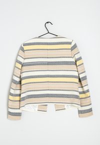 Randig jacka i vitt, gult, grått och persika. Har en avslappnad passform, långa ärmar och en delad nederkant bak. Tillverkad av texturerad tyg.