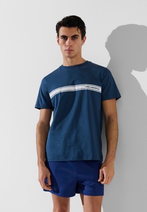 Camiseta de algodón azul marino de manga corta, con una franja horizontal blanca y el texto "KARL LAGERFELD" en el pecho.