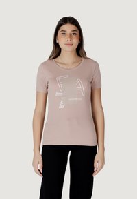 Camiseta ajustada de color rosa claro con escote redondo y mangas cortas. Presenta un diseño gráfico blanco en el centro y una textura de algodón suave.