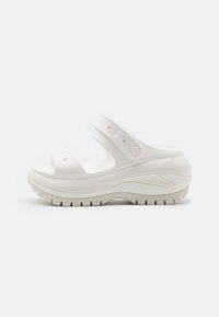 Sandalias de plataforma blancas con puntera abierta, dos correas ajustables, suelas texturizadas, material suave y un diseño redondeado y acolchado.