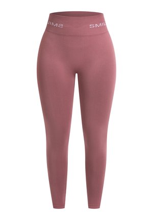 Leggings taille haute roses en tissu extensible. Présentent une texture lisse et une bande avec "SMILE" imprimé en blanc.