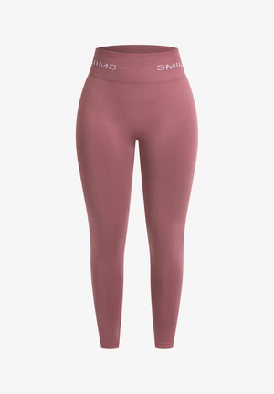 Lyserøde højtaljede leggings lavet af strækbart stof. Har en glat tekstur og et bånd med "SMILE" trykt i hvidt.