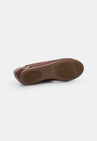 Braune Leder-Schuh mit abgerundetem Zehenbereich, leicht strukturiertem Außensohle und dualem Muster aus Gummi-Griffen für besseren Halt.