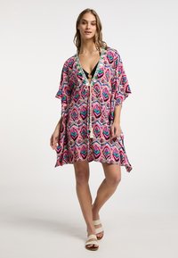 Barviti kimono-slog prekrivač z bold ikat vzorcem v roza, modri in zeleni barvi. Ima V-izrez, zategovanje s črto in široke rokave.