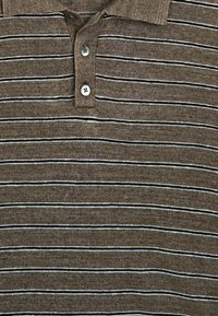 Polo en tricot marron avec de fines rayures horizontales blanches et noires et trois boutons sur le plastron du col.