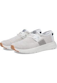 Scarpe da ginnastica leggere beige con parte superiore in maglia testurizzata, suola bianca e dettagli neri a strisce. Presentano un logo e un sistema di allacciatura minimale.