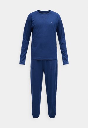 Conjunto de roupa de lazer azul-marinho com um top de gola redonda de mangas longas e calças ajustadas com bolsos, feito de um tecido suave e texturizado.