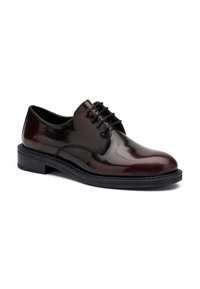 Scarpa da uomo in pelle lucida marrone scuro, con lacci neri e suola spessa nera, mostrata da un leggero angolo su uno sfondo bianco.