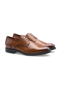 Chaussures en cuir marron avec une texture lisse, bout rond, design classique à lacets et petit talon en caoutchouc noir.
