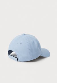 Lys blå baseballcaps laget av bomull med buet skjerm, justerbar stropp og ventilasjonsluftinger bak for pusteevne.
