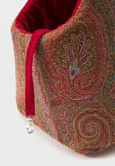 Soft fabric bag with intricate red, gold, and teal paisley pattern, red velvet interior, and silver metal clasp on red strap.