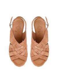 Ruske nahkakankaiset sandaalit avokannalla, jossa on kudotut hihnat ja säädettävät nilkkahihnat, näkymä ylhäältä valkoista taustaa vasten.