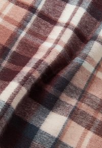 Tecido de xadrez em tons quentes de burgundy, creme e azul-marinho. Textura de lã suave com padrão de cheques distinto. Aparência ligeiramente amarrotada.