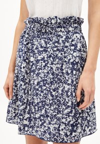 Floral skirt in navy and white, featuring a gathered elastic waistband with a tie, above the knee length, and lightweight fabric with a textured pattern.