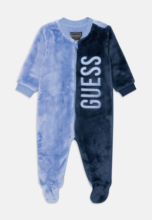 Fleece onesie with a blue and dark blue color block design, front zipper, and "GUESS" logo in light blue on the dark side.