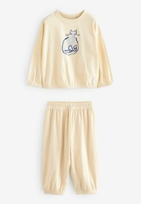 Set a due pezzi color crema composto da una maglia a maniche lunghe con una grafica di un gatto blu e pantaloni elasticizzati a coste con orli a polsino.