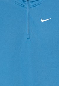 Világoskék, hosszúujjú sportpulóver félcipzáros nyakkal és egy kis fehér Nike logóval a mellkason. Sima, rugalmas anyag.