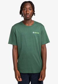 Camiseta de algodón verde con cuello redondo, que presenta un pequeño logo "element" en blanco y amarillo en el lado izquierdo del pecho. Mangas cortas, ajuste relajado.