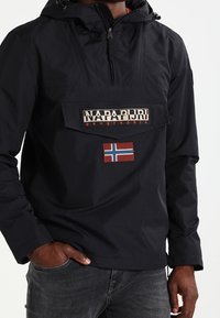 Czarna bluza z kapturem, posiadająca przednią kieszeń oraz haftowane logo „NAPAPIJRI”. Zawiera naszywkę z flagą Norwegii.