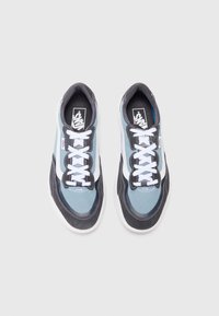 Tênis com um design azul claro e preto, materiais de malha e camurça, atacadores brancos e logotipo Vans na língua e na lateral.