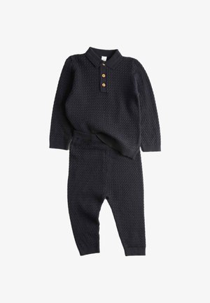 Námornícky pletený dvojdílný outfit s dlouhými rukávy, límcem a třemi dřevěnými knoflíky. Svetr má strukturovaný design; kalhoty jsou fitted.