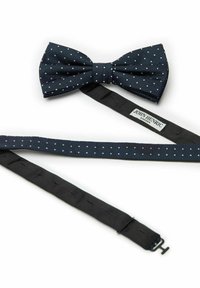 Mörkblå prickig fluga i texturerat tyg, med svart rem och spänne för fästning. Etiketten säger "JOHN HENRIC SWEDEN."