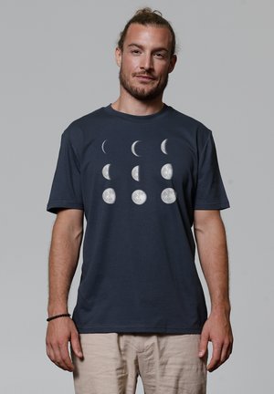 Navy blue cotton t-shirt featuring a moon phase graphic in white. The design includes crescent and full moons arranged in rows.