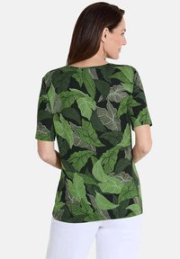 Korte mouwen shirt met een groen loofpatroon op een donkere achtergrond, gemaakt van een lichtgewicht stof met een ontspannen pasvorm en een ronde halslijn.