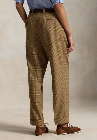 Καφέ καρώ παντελόνι φτιαγμένο από υφασμάτινη δομή, με ψηλή μέση, πλαϊνές τσέπες και με σούρες στο στρίφωμα, συνδυασμένο με καφέ καθημερινά παπούτσια.