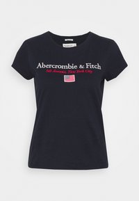 Camiseta de algodón azul marino de manga corta, con texto bordado en blanco y rojo: "Abercrombie & Fitch, 5th Avenue, Nueva York" y una pequeña bandera.