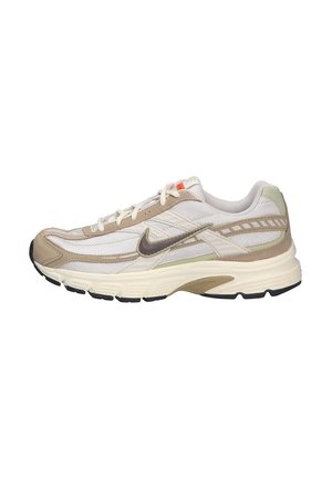 Beige Nike hardloopschoen met een bovenwerk van mesh en suede, textuurpanelen, witte tussenzool, zwarte buitenzool en grijze accenten. Veters en logo in donkerbruin.