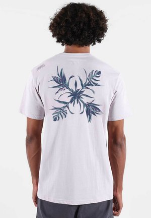 T-shirt en coton rose clair présentant un motif floral foncé dans le dos, manches courtes et coupe décontractée.