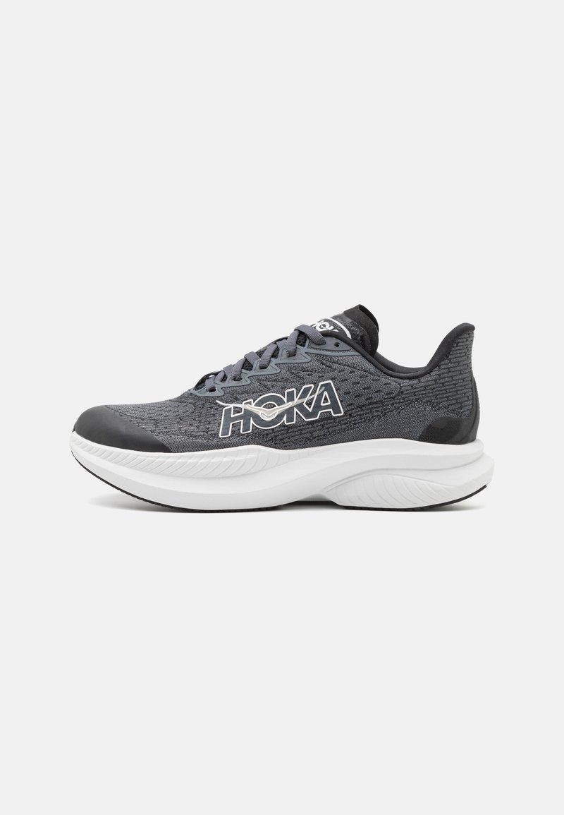 Chaussure de course Hoka en mesh gris foncé avec semelle intermédiaire blanche. Caractéristiques : bout arrondi, logo contrastant et motif texturé sur le dessus.