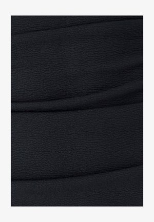 Mustmust tekstuuriga must kangas horisontaalsete volangidega, millel on laineline muster. Materjal näeb välja pehme ja veniv.