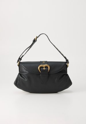 Bolsa de mão em pele preta com formato arredondado, apresentando um detalhe em metal dourado em forma de coração e uma alça estampada. Textura suave com pregas discretas.