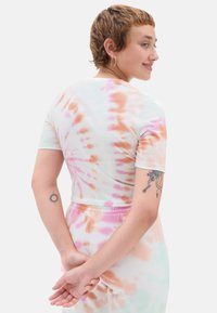Kortærmet tætsiddende top i tie-dye med pastelfarver i pink, orange og grøn. Glat stof; rund halsudskæring; bæres med matchende pastelfarvede bunddele.