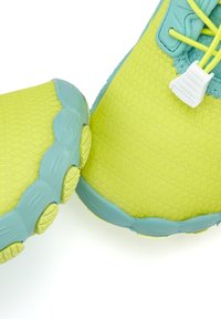 Limegrüne Sportschuhe mit einem strukturierten Mesh-Obermaterial und türkisfarbenen Gummielementen. Verfügt über eine einzigartige, gerundete Sohle mit Griffmustern.