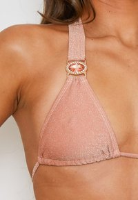 Roze driehoek bikini top van glanzende stof, met een decoratieve roségouden accent bij de band, een gladde textuur en subtiele glitter.