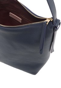 Ciemnoniebieska skórzana torebka z fakturowanym wykończeniem, złotym zamkiem błyskawicznym i bordowym wnętrzem. Posiada zamek błyskawiczny oraz jeden uchwyt.