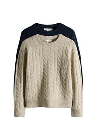 Light beige cable-knit sweater in front, dark blue behind. Both have a ribbed crew neck and cuffs, featuring textured, raised patterns.
