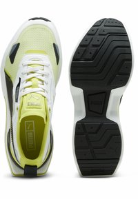 Scarpe sportive verde lime e nere con tomaia in rete, accenti bianchi, suola testurizzata e distintivo marchio Puma sulla linguetta e sulla soletta.