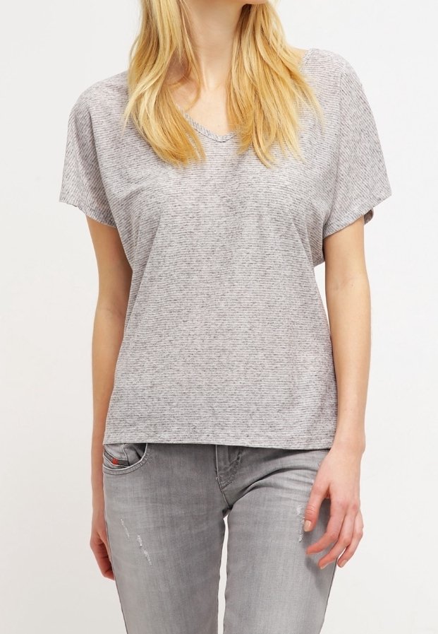 Camiseta gris de manga corta con cuello en V, que presenta un patrón de rayas texturizado. Combinada con jeans desgastados de color gris claro.
