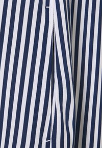 Sininen ja valkoinen raidoitettu kangas, jossa on pystysuorat viivat, sivuaukko ja pehmeä rakenne, joka sopii erinomaisesti arkivaatteisiin.