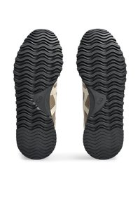 Musta kumipohja, jossa on aaltoileva kuvio; vahvistettu kanta; päällinen beige kankaasta, jossa on geometrisia leikkauksia.