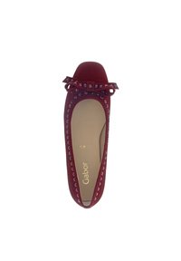 Balletflat in diep rood suede met een ronde neus, versierd met kleine bijpassende studs langs de rand en een centrale strikaccent.