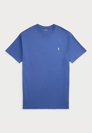 T-shirt básica de gola redonda em tecido de algodão azul sólido. Mangas curtas, corte descontraído e pequeno logótipo bordado no lado esquerdo do peito.