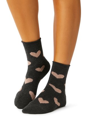 Dunkelgraue Socken mit rosa Herzmustern, gerippter Textur und Knöchelhöhe, mit einer glatten Oberfläche und tailliertem Design.